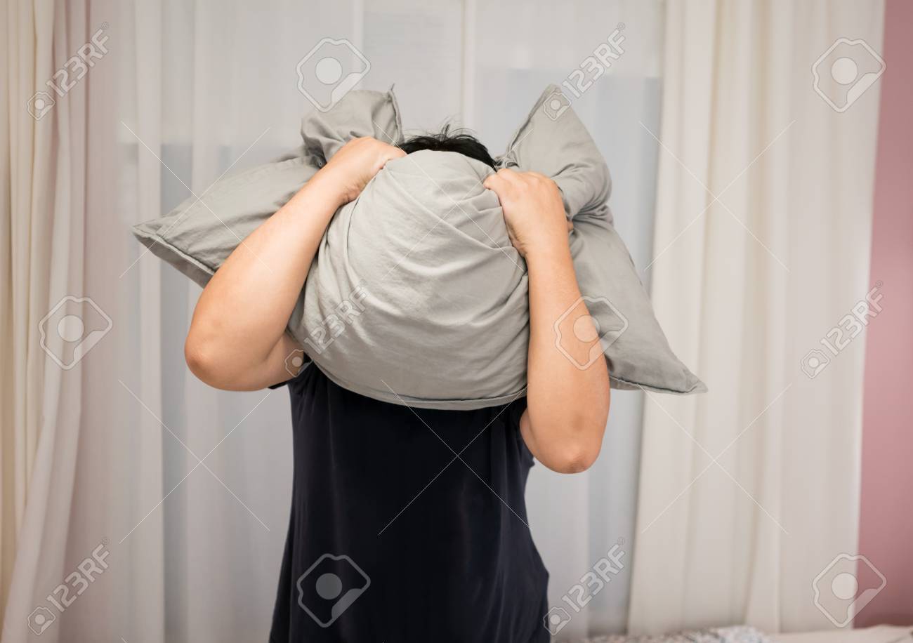 83663721-depressed-man-covering-his-face-with-pillow-and-screaming-in-anger-in-his-room.jpg