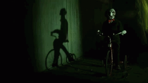 saw-billy-the-puppet-riding-bicycle-mhb0nkzcu7g3qi0w.gif